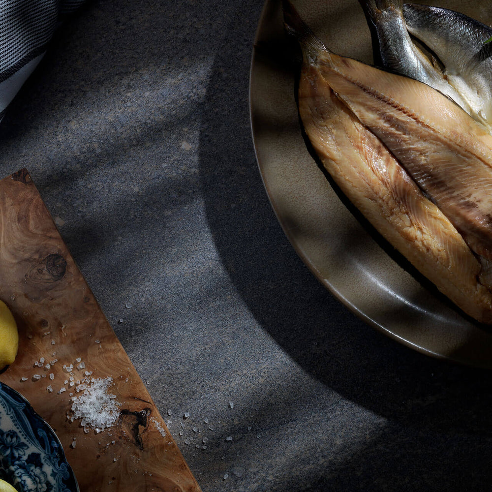 Jaffy's gently smoked kippers presented beautifully on a plate ready for serving with fresh lemon wedges.